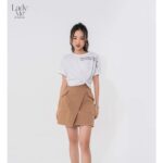 Chân váy kaki ngắn chữ A vạt chéo LADY ME by Eva de Eva 22SCVO022B